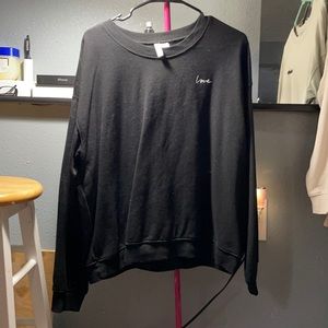 Black sweatshirt with “love” stitched into chest.